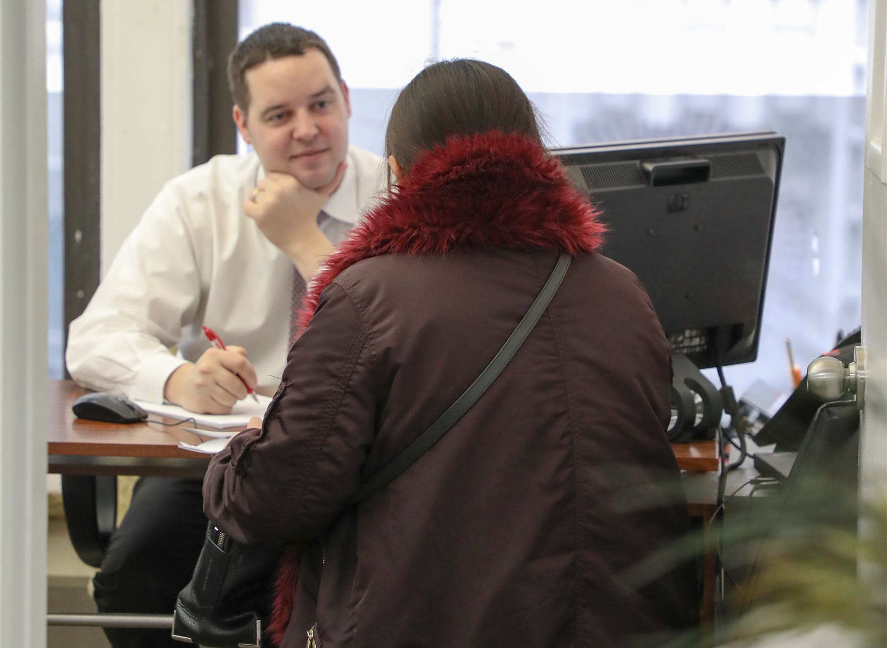 A man and woman sitting at a desk in front of a computer at NYC