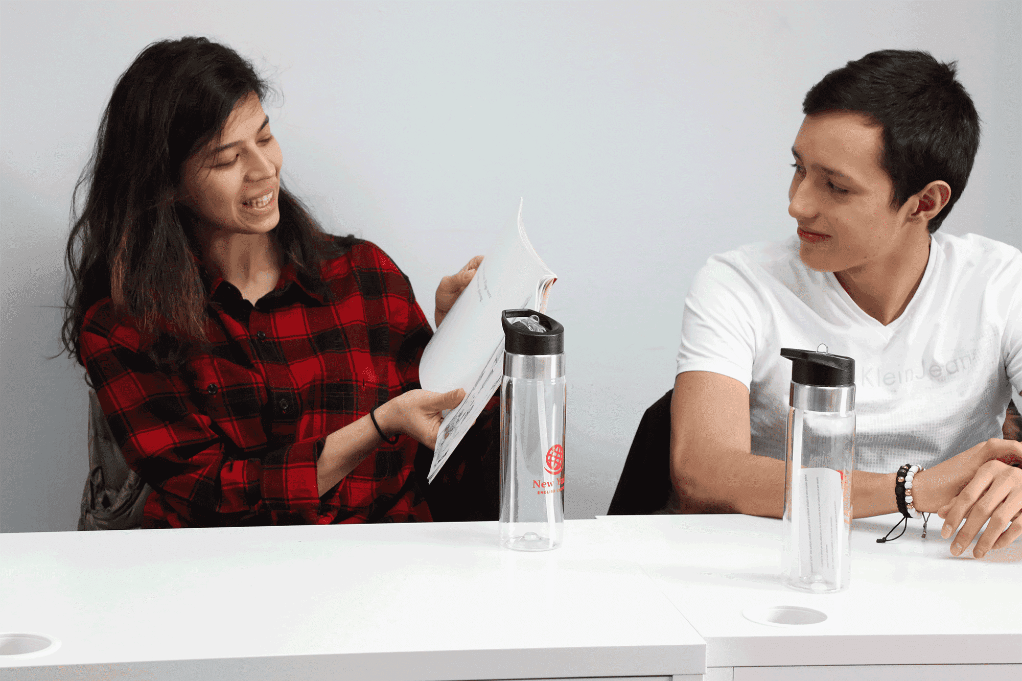 Two individuals at a table , participating in lessons at New York English Center.